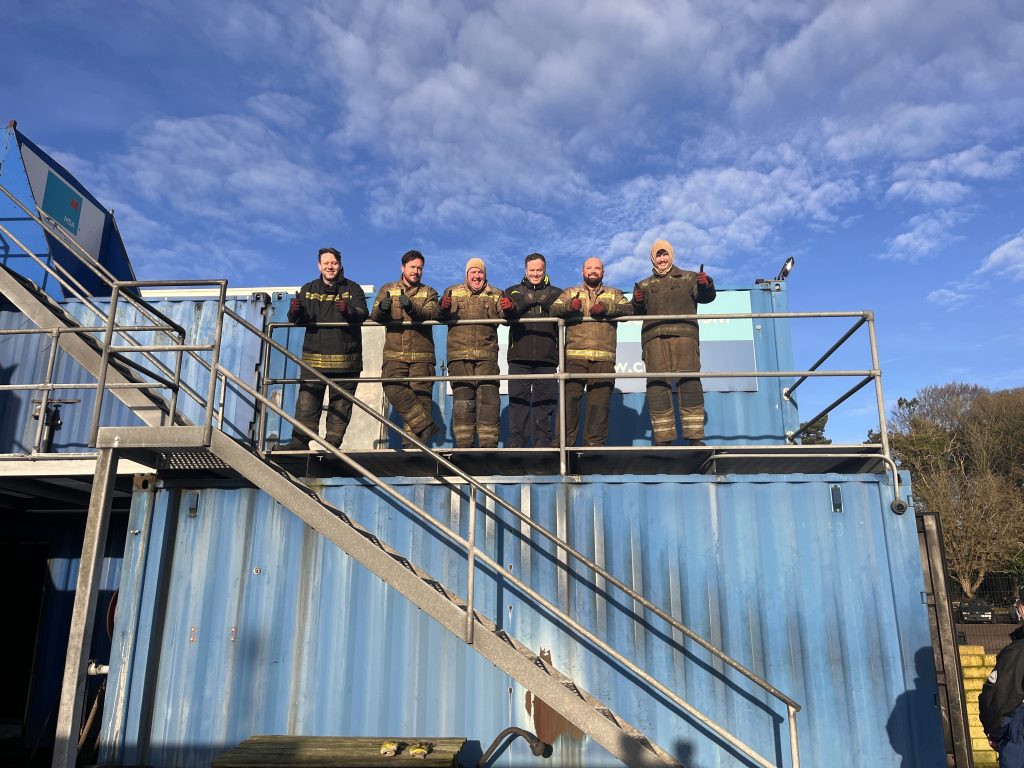 Delegates on the fire training ground smiling on a balcony | MSA Dover STCW Basic Safety Training Week